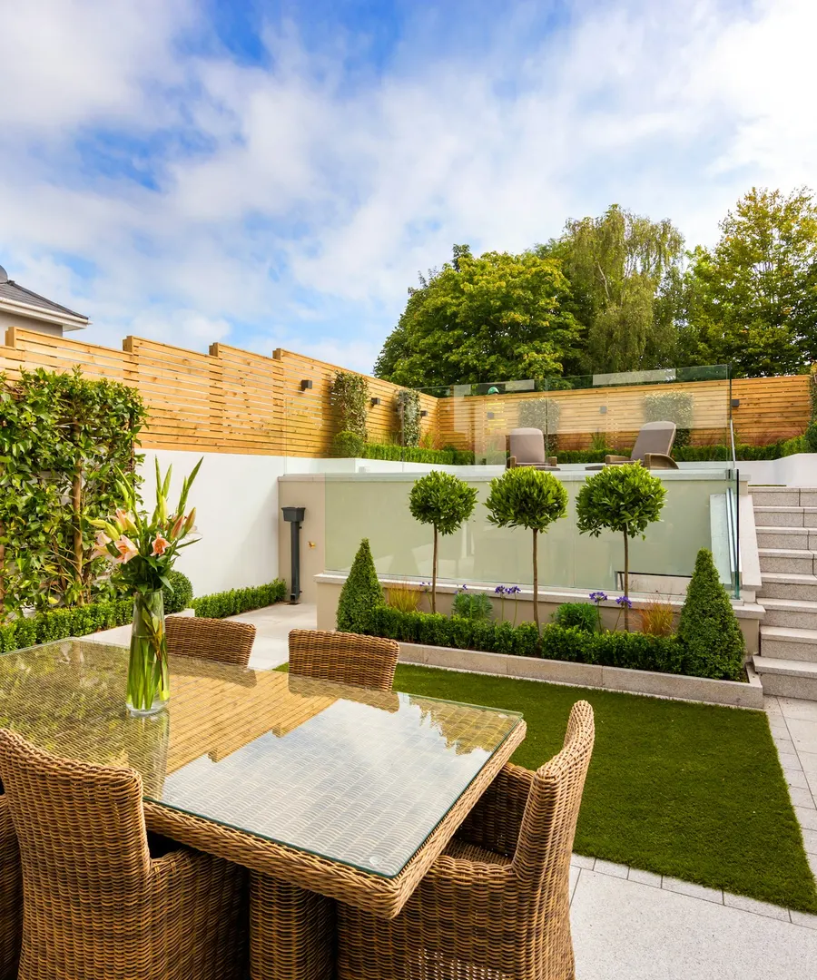 Jardin entretenu avec gazon, haie basse et arbres taillés en boule